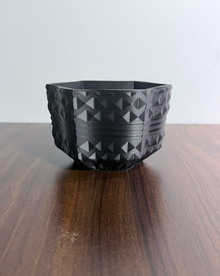 Six-sided black 3D-printed planter covered in small pyramid studs